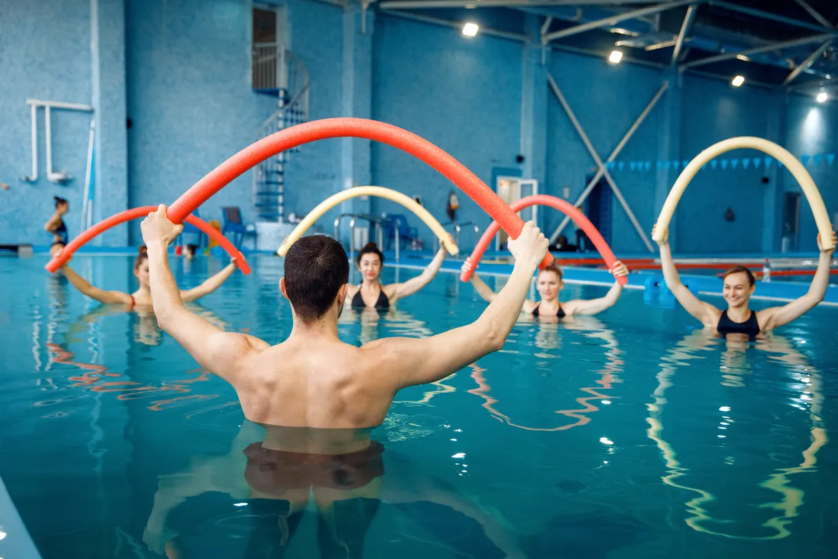ausbilder-und-weibliche-gruppe-training-im-pool